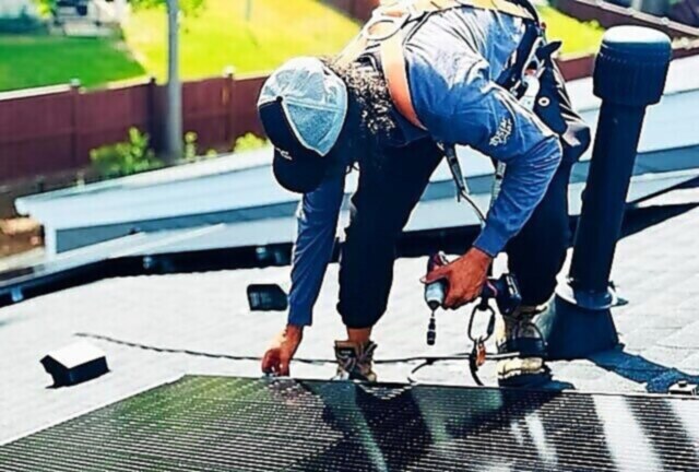 Solar panels on a roof with a 10 Star technician on site